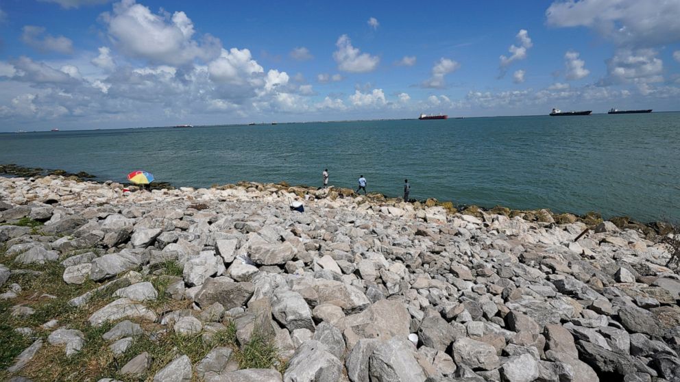 FILE - People fish in Galveston Bay, on Sept. 4, 2020, in Galveston, Texas. President Joe Biden signed on Friday, Dec. 23, 2022, a large defense bill that includes the Water Resources Development Act of 2022. It includes major projects, such as the I