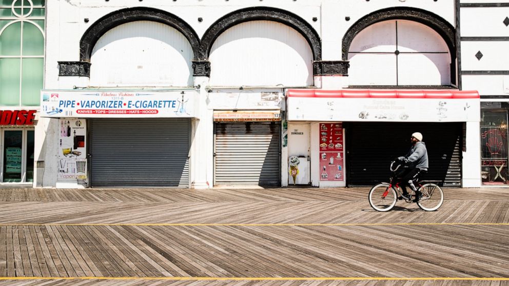 A cyclist rides past shuttered businesses during the coronavirus outbreak on the boardwalk in Atlantic City, N.J., Tuesday, April 28, 2020. (AP Photo/Matt Rourke)