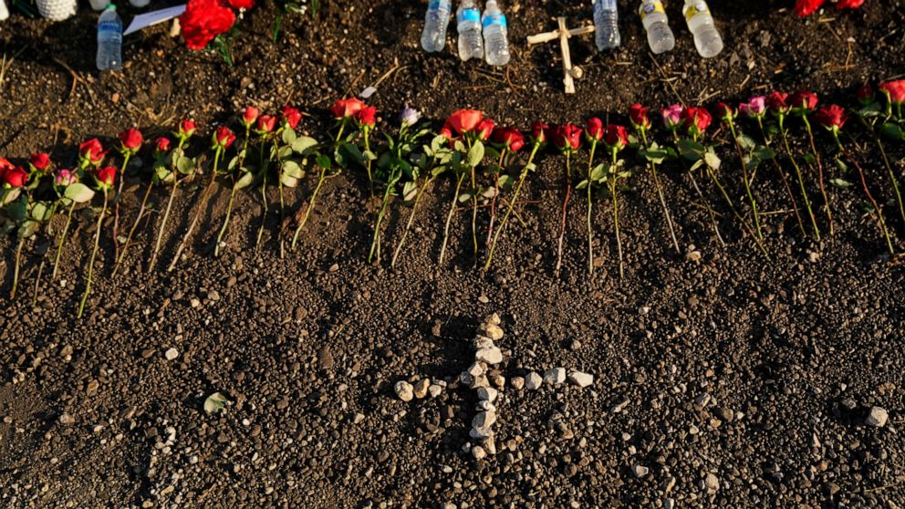 A makeshift memorial at the site where officials found dozens of people dead in an abandoned semitrailer containing suspected migrants include flowers, water bottles and candles, Wednesday, June 29, 2022, in San Antonio. (AP Photo/Eric Gay)