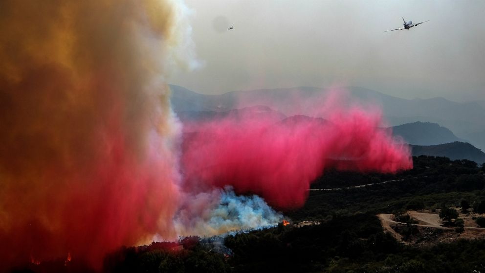 An air tanker drops retardant on a wildfire Wednesday, Oct. 13, 2021, in Goleta, Calif. (AP Photo/Ringo H.W. Chiu)