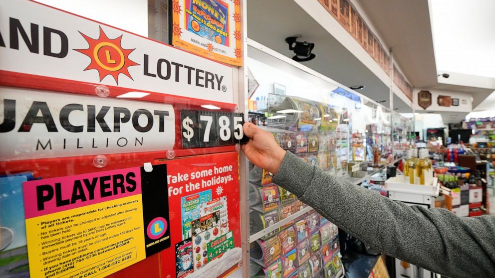 A clerk at Broad Street Liquors updates the Mega Millions jackpot at the store's lottery counter, Tuesday, Jan. 3, 2023, in Timonium, Md. (AP Photo/Julio Cortez)