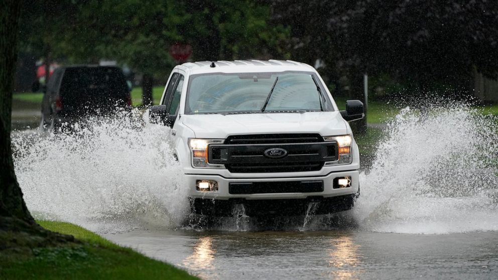 A truck drives through a flooded street, Friday, July 16, 2021, in Dearborn Heights, Mich. Detroit area residents are still drying out their basements from the flooding last month, but now more flooding is on the horizon as a heavy rain front moves t