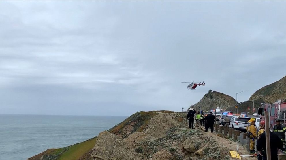 In this image from video provided by Cal Fire San Mateo, Santa Cruz Unit, emergency personnel respond to the scene after a Tesla plunged off a cliff along the Pacific Coast Highway, Monday, Jan. 2, 2023, in Northern California, near an area known as 
