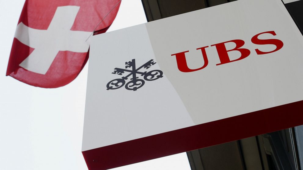 FILE - This April 24, 2014, file photo shows the logo of Swiss bank UBS and the Swiss flag in Zurich, Switzerland. The multinational investment bank has ended support for offshore drilling in the Arctic amid efforts to tackle climate change, a move t