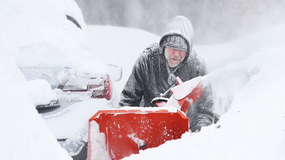 Mike Gippon plows snow in the driveway outside his home in Buffalo, N.Y.'s Elmwood Village on Monday, Dec. 26, 2022. Clean up is currently under way after a blizzard hit four Western New York counties. (Joseph Cooke/The Buffalo News via AP)
