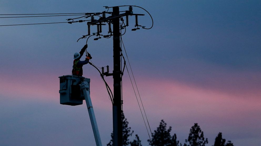 FILE - In this Nov. 26, 2018, file photo, a Pacific Gas & Electric lineman works to repair a power line in fire-ravaged Paradise, Calif. California regulators will consider suspending a $200 million fine against Pacific Gas & Electric for neglecting 