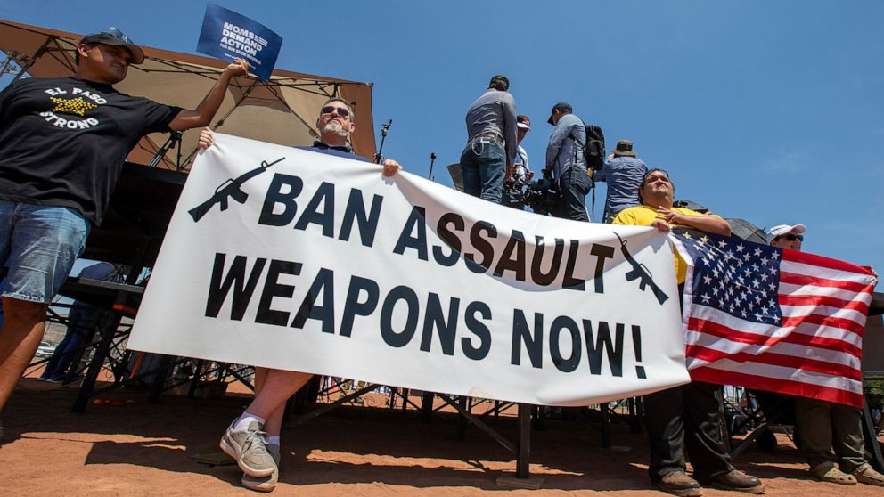 FILE - Demonstrators hold a banner to protest the visit of President Donald Trump to the border city after the Aug. 3 mass shooting in El Paso, Texas, on Aug. 7, 2019. A gunman killing multiple elementary school children and adults in Texas on Tuesda