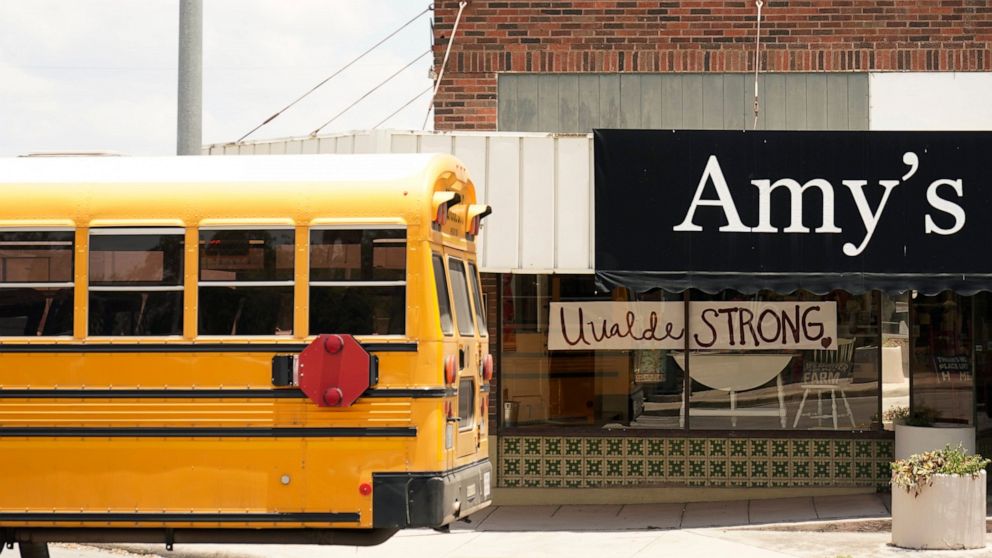 A school bus passes a 'Uvalde Strong' sign placed in the window of a business to honor the victims killed in the recent school shooting at Robb Elementary, Thursday, June 9, 2022, in Uvalde, Texas. The Texas elementary school where a gunman killed 19