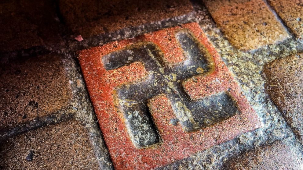 FILE - One of about 60 floor tiles emblazoned with swastika-style crosses in the entrance to the Longview Community Church in Longview, Wash., is seen on March 3, 2016. A Longview church established in 1925 bears tiles with symbols that were once see