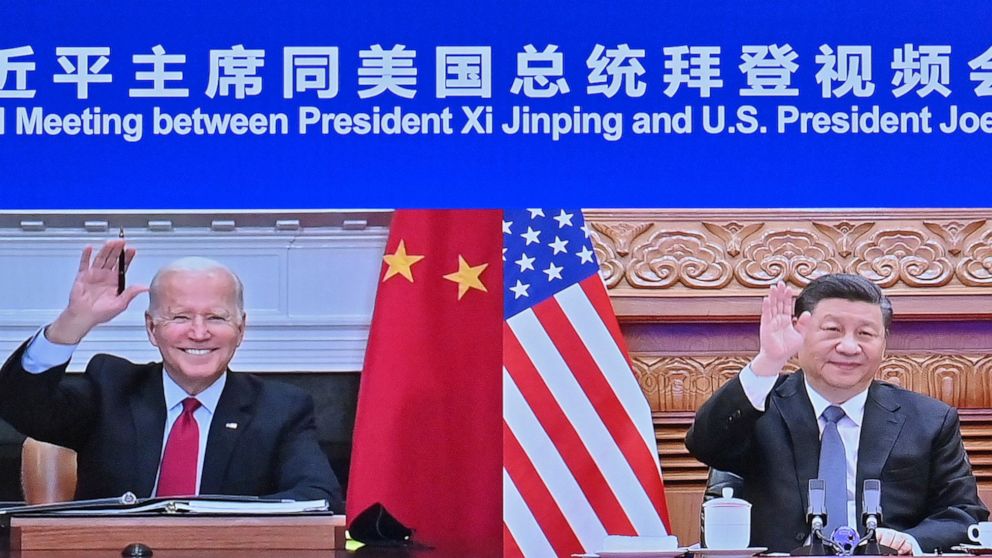 In this photo released by Xinhua News Agency Chinese President Xi Jinping, right and U.S. President Joe Biden appear on a screen as they hold a meeting via video link, in Beijing, China, Tuesday, Nov. 16, 2021. President Joe Biden opened his virtual 