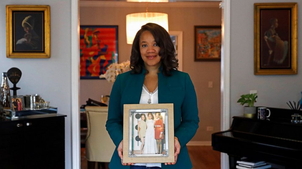 Robin Rue Simmons, alderwoman of Evanston's 5th Ward poses for a portrait holding a photograph of her mother, aunt and grandmother in her home in Evanston, Ill., Friday, April 9, 2021. The Chicago suburb is preparing to pay reparations in the form of