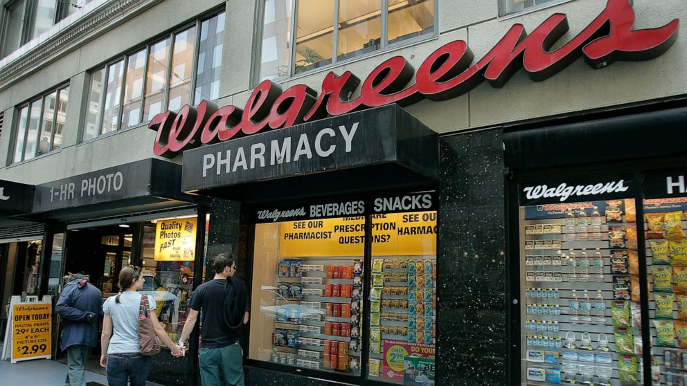 FILE - In this June 26, 2006 file photo, window shoppers look at a Walgreens storefront in San Francisco. Walgreens says it will close five more stores in San Francisco next month because of organized retail theft. The drugstore chain has closed at l
