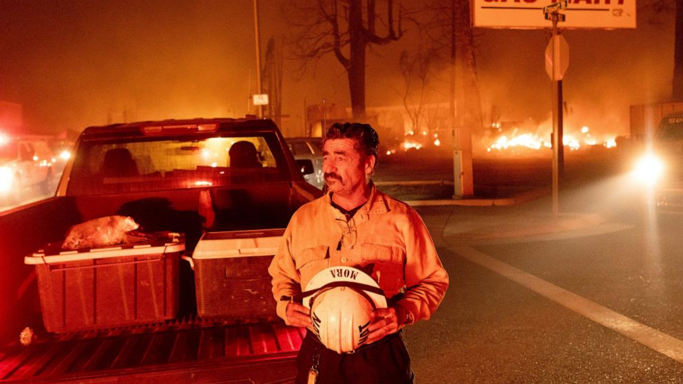 Battalion Chief Sergio Mora watches as the Dixie Fire tears through the Greenville community of Plumas County, Calif., on Wednesday, Aug. 4, 2021. The fire leveled multiple historic buildings and dozens of homes in central Greenville. (AP Photo/Noah 