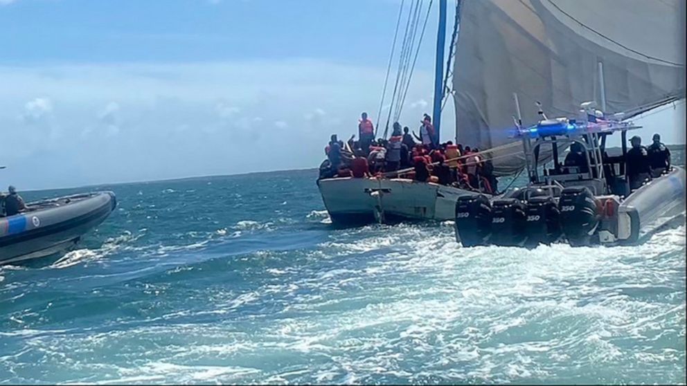 In this image posted on the USCGSoutheast Twitter page, rescue crews safely transfer people from a grounded vessel believed to be carrying migrants, to U.S. Coast Guard ships, Saturday, Aug. 6, 2022, off the coast of Key Largo, Fla., near the gated c