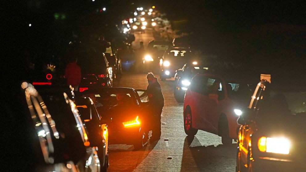 FILE - Motorists make their way along as people search for a vantage point of the erupting Mauna Loa volcano, Friday, Dec. 2, 2022, near Hilo, Hawaii. Officials monitoring the Mauna Loa eruption on Hawaii's Big island said Wednesday, Dec. 7, the lava