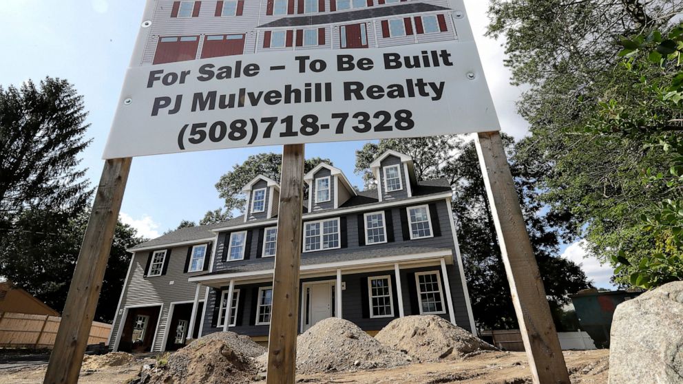 In this Sept. 3, 2019 photo a for sale sign, top, rests in front of a newly constructed home, in Norwood, Mass. On Thursday, Oct. 17, the Commerce Department reports on U.S. home construction in September. (AP Photo/Steven Senne)