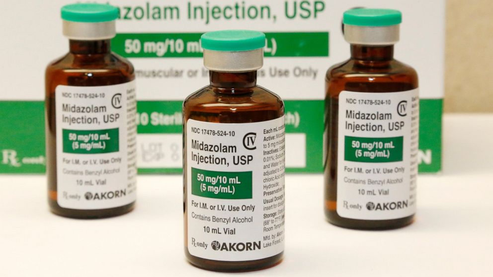 FILE - This July 25, 2014 file photo shows bottles of the sedative midazolam at a hospital pharmacy in Oklahoma City. Many of the medications being used to sedate and paralyze COVID-19 patients placed on ventilators and to also treat their pain are t
