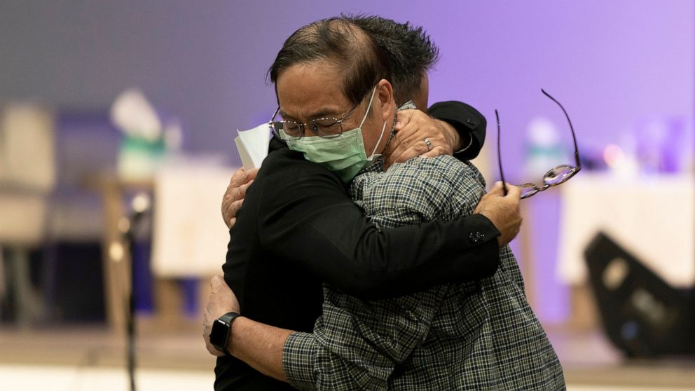 Jason Aguilar, left, a senior pastor at Arise Church, comforts Billy Chang, a 67-year-old Taiwanese pastor who survived Sunday's shooting at Geneva Presbyterian Church, during a prayer vigil in Irvine, Calif., Monday, May 16, 2022. Authorities say a 