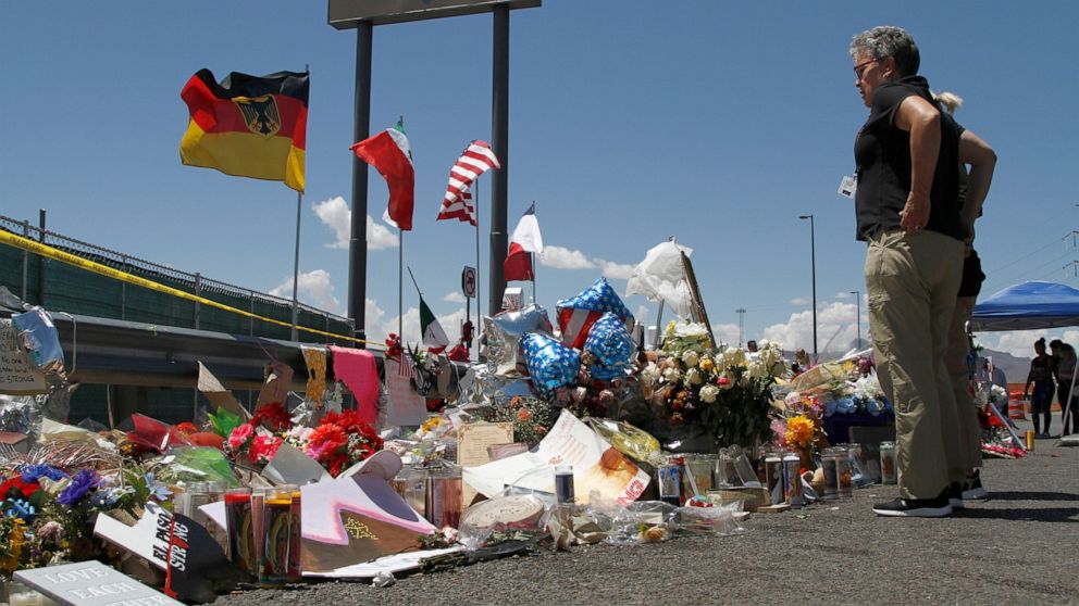 FILE - In this Aug. 12, 2019 photo, mourners visit the makeshift memorial near the Walmart in El Paso, Texas, where 22 people were killed in a mass shooting that police are investigating as a terrorist attack targeting Latinos. White supremacists and