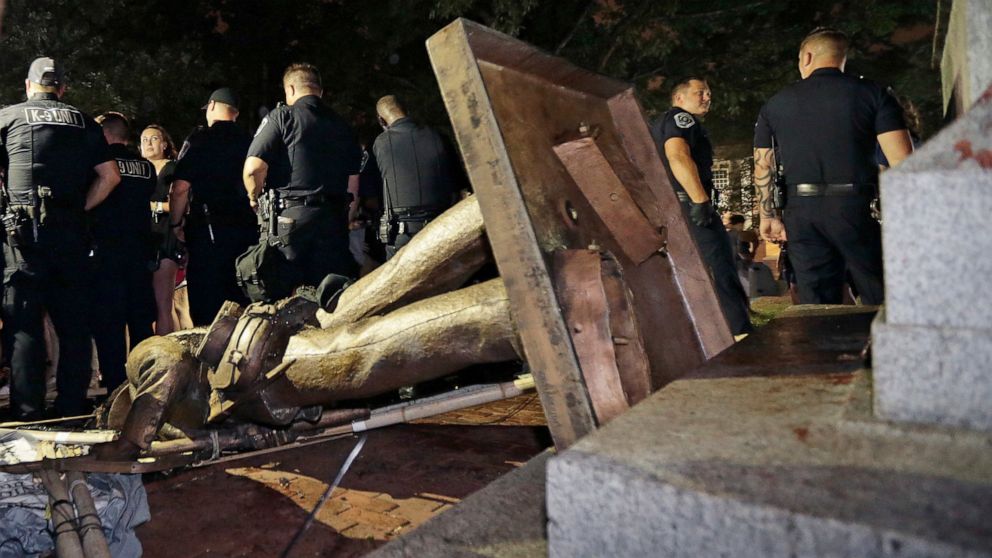 FILE - In this Aug. 20, 2018, file photo, police officers stand guard after the Confederate statue known as Silent Sam was toppled by protesters on campus at the University of North Carolina in Chapel Hill, N.C. A national civil rights organization f