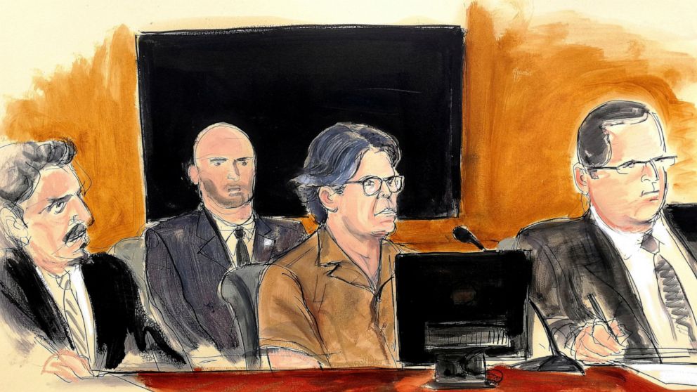 FILE - In this April 13, 2018 courtroom sketch, Keith Raniere, center, attends a hearing at court in the Brooklyn borough of New York. Attorneys for Raniere, the former leader of the cult-like NXIVM group, want a new federal judge to consider a motio