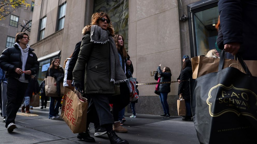 Shoppers carry bags down Fifth Avenue on Friday, Nov. 25, 2022, in New York. The Commerce Department releases retail sales data for November on Friday, Dec. 15.(AP Photo/Julia Nikhinson, File)