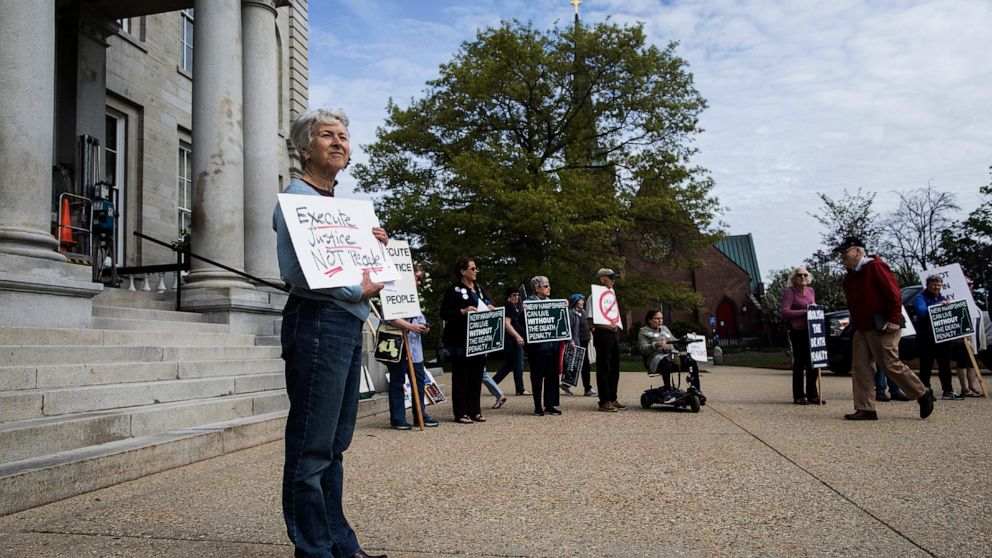 Doris Hampton of Canterbury stands in front of the State house in Concord, N.H., Thursday, May 23, 2019, to greet lawmakers ahead of the vote to override the death penalty veto by Governor Chris Sununu. (Geoff Forester/The Concord Monitor via AP)