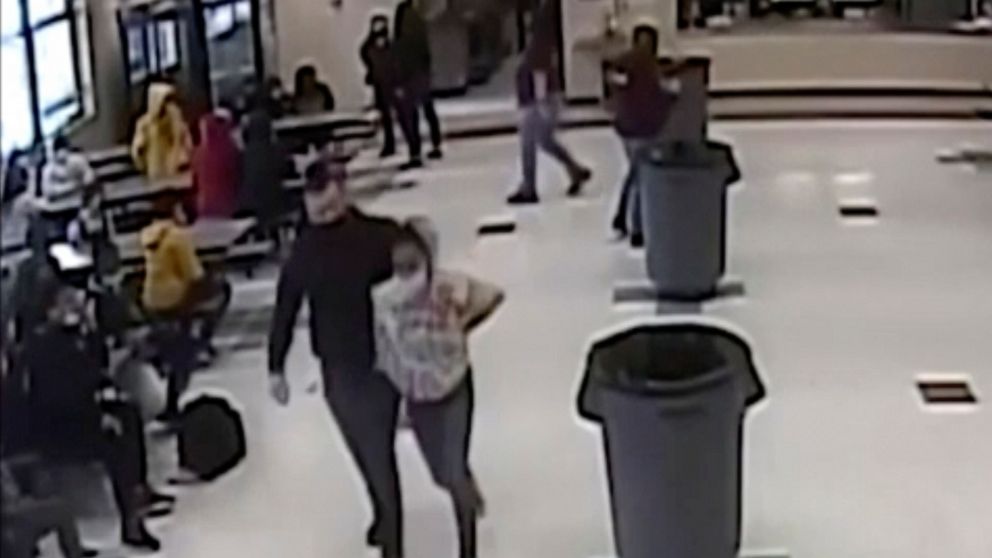In this frame grab from surveillance video provided by the Kenosha Unified School District, an off-duty police officer escorts a 12-year-old student out of a school cafeteria following a lunchtime fight, in Kenosha, Wis., on March 4, 2022. Earlier in