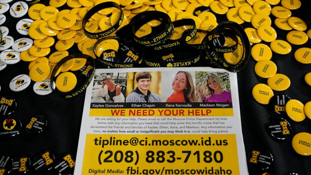 FILE - A flyer seeking information about the killings of four University of Idaho students who were found dead is displayed on a table along with buttons and bracelets on Nov. 30, 2022, during a vigil in memory of the victims in Moscow, Idaho. A susp