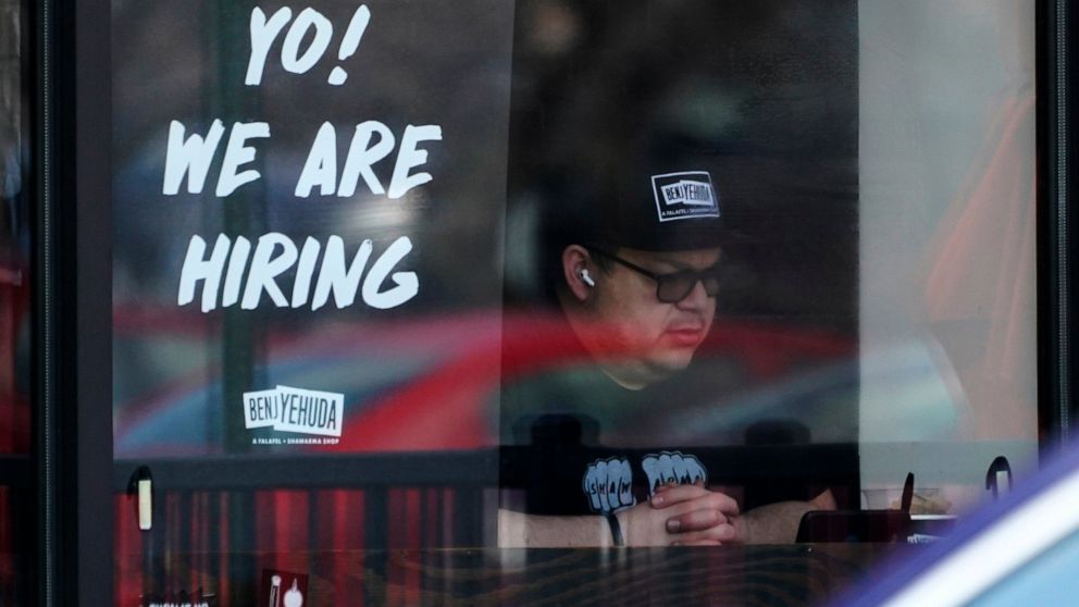 FILE - A hiring sign is displayed at a restaurant in Schaumburg, Ill., April 1, 2022. The white-hot demand for U.S. workers cooled a bit in April, though the number of unfilled jobs remains high and companies are still desperate to hire more people. 