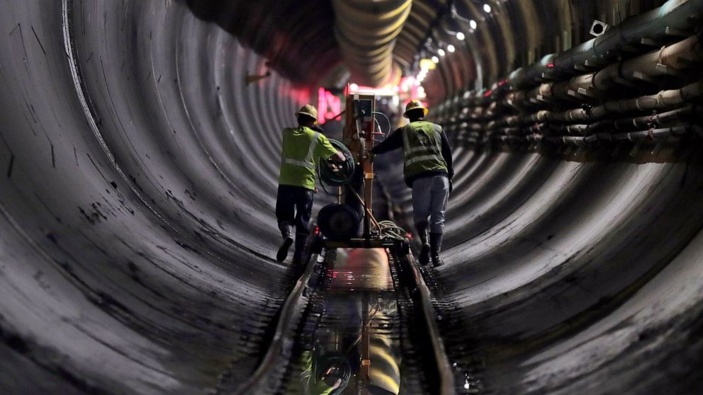 FILE - Tunnel workers push equipment up a rail track to a machine boring a 2.5-mile bypass tunnel for the Delaware Aqueduct in Marlboro, N.Y., on May 16, 2018. A long-planned temporary shutdown of a leaking aqueduct that supplies about half of New Yo