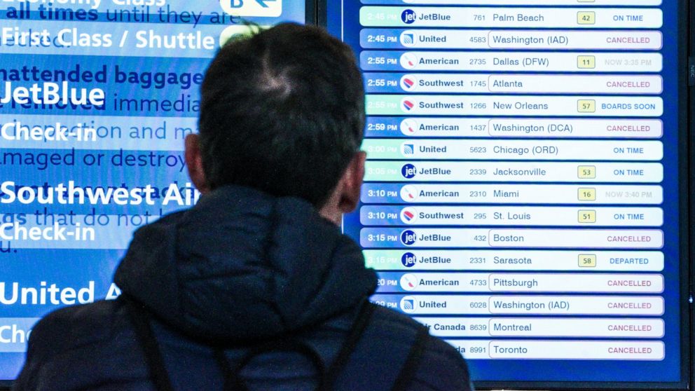 A passenger checks flight departures showing cancellations at Laguardia Airport, Friday Dec. 23, 2022, in New York. (AP Photo/Bebeto Matthews)
