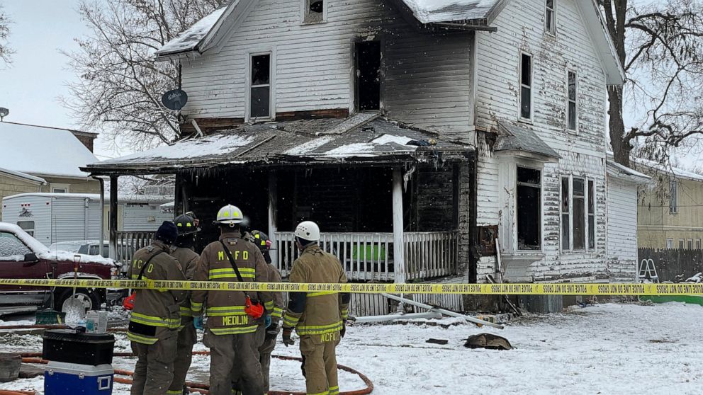 Mason City, Iowa, firefighters look on after containing a fire at a home on Washington Avenue in Mason City on Wednesday, Nov., 16, 2022. The cause of the fire is under investigation. The fire killed four children and injured two other people. (Matth