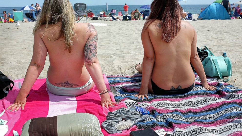 FILE - In this Aug. 26, 2017 file photo, women go topless as they participate in the Free the Nipple global movement during Go Topless Day at Hampton Beach, N.H. New Hampshire's highest court is set to rule Friday, Feb. 8, 2019, on the case of three 