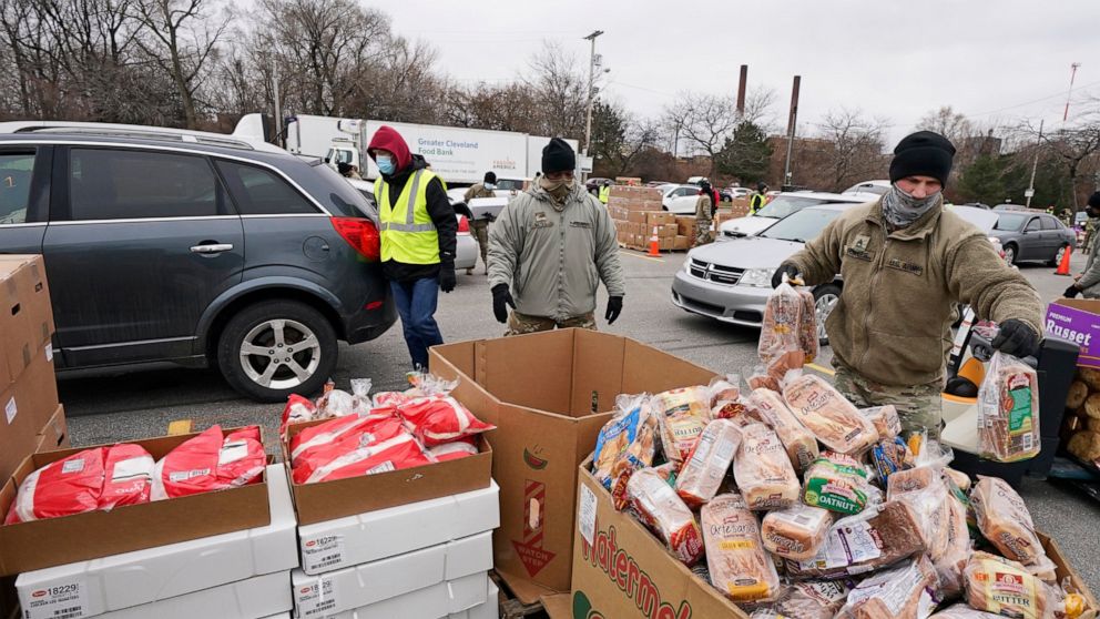 FILE - Sgt. Kevin Fowler organizes food at a food bank distribution by the Greater Cleveland Food Bank, Thursday, Jan. 7, 2021, in Cleveland. Food banks across America say these economic conditions are pushing demand for their support higher, at a ti