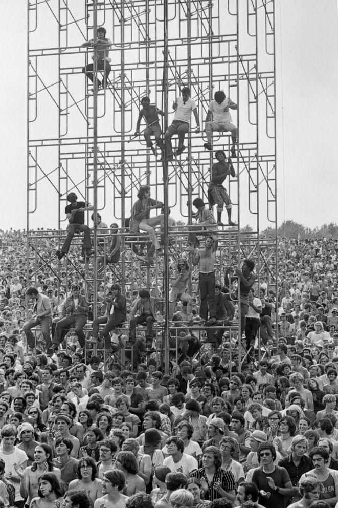 PHOTO: Members of the audience climb the sound tower to secure a better view at the Woodstock music festival, in Bethel, N.Y., Aug. 15, 1969.