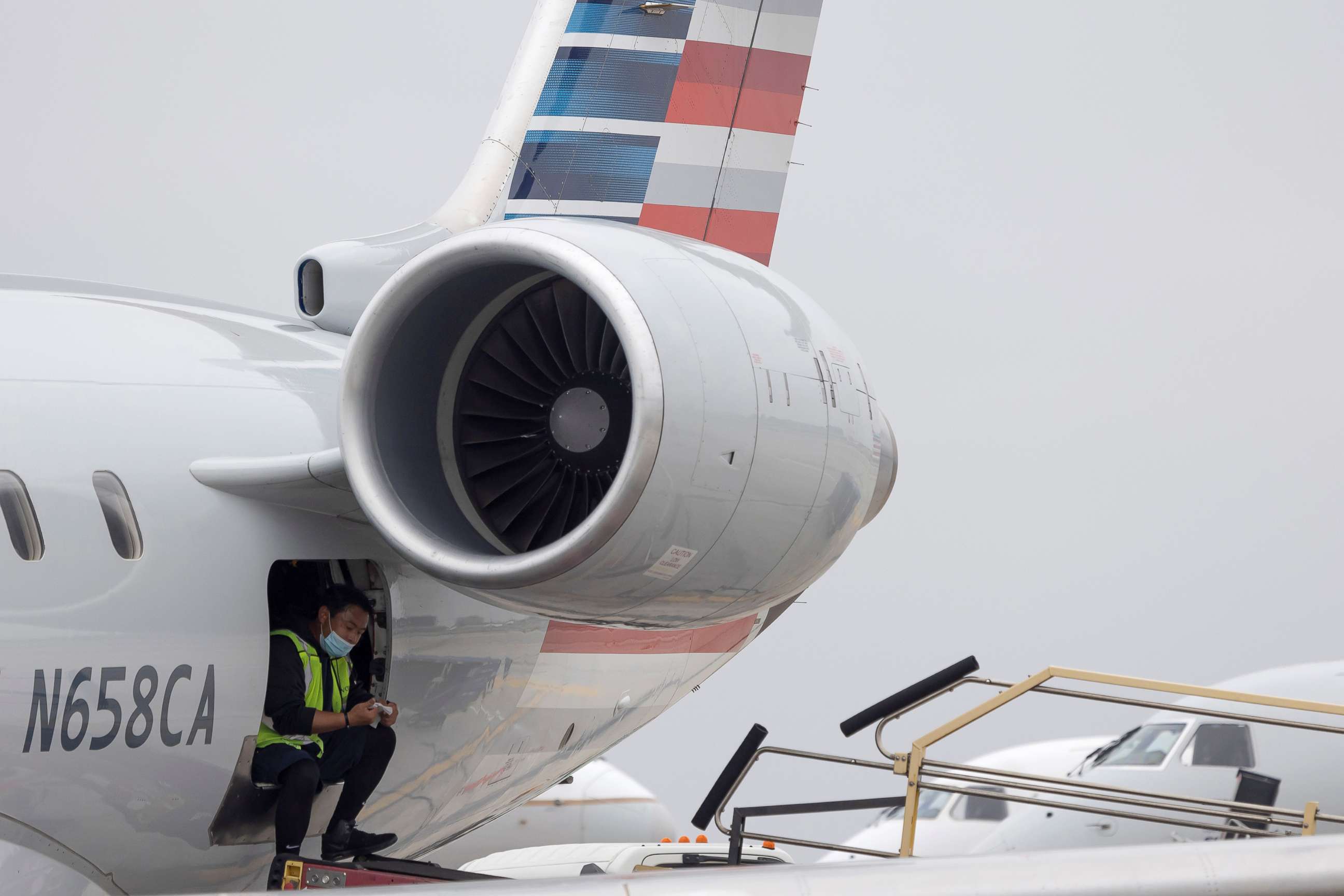 PHOTO: An American Airlines worker waits at the Los Angeles international airport as more than 1,400 American Airlines flights over the weekend were cancelled due to staff shortages and unfavorable weather, Oct. 31, 2021, in Los Angeles.