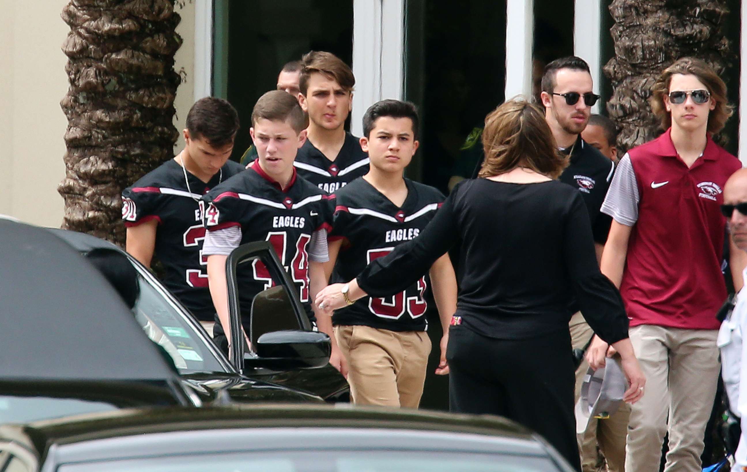 PHOTO: Members of the Marjory Stoneman Douglas High School football team depart the service at the Church by the Glades for Aaron Feis, the football coach who was killed at the school shooting last week, Feb. 22, 2018, in Coral Springs, Fla.