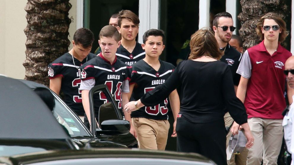 PHOTO: Members of the Marjory Stoneman Douglas High School football team depart the service at the Church by the Glades for Aaron Feis, the football coach who was killed at the school shooting last week, Feb. 22, 2018, in Coral Springs, Fla.