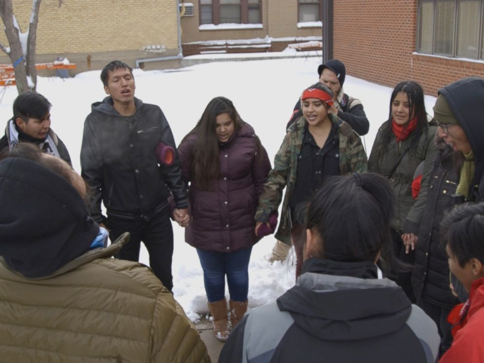 PHOTO: The International Indigenous Youth Council forms a prayer circle after delivering supplies to the Morton County Law Enforcement Center.