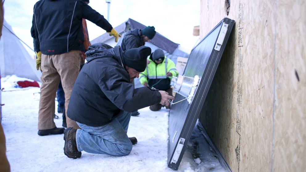 PHOTO: Henry Red Cloud from the Pine Ridge Reservation in South Dakota secures an outlet to a solar air furnace at the Oceti Sakowin Camp on the Standing Rock Reservation in Cannon Ball, North Dakota, Dec. 21, 2016.