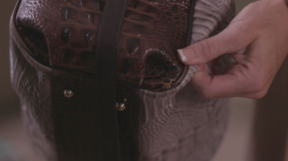 Det. Brittany Hilton shows the bullet hole in the bottom right corner of her purse that she says was caused by her holstered P320 handgun firing unprompted.