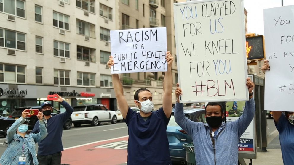 Lenox Hill Hospital workers hold signs in support of protesters in New York City.