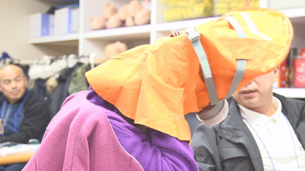 A woman in Seung Yup Woo's survivalist class tries on a mask. 