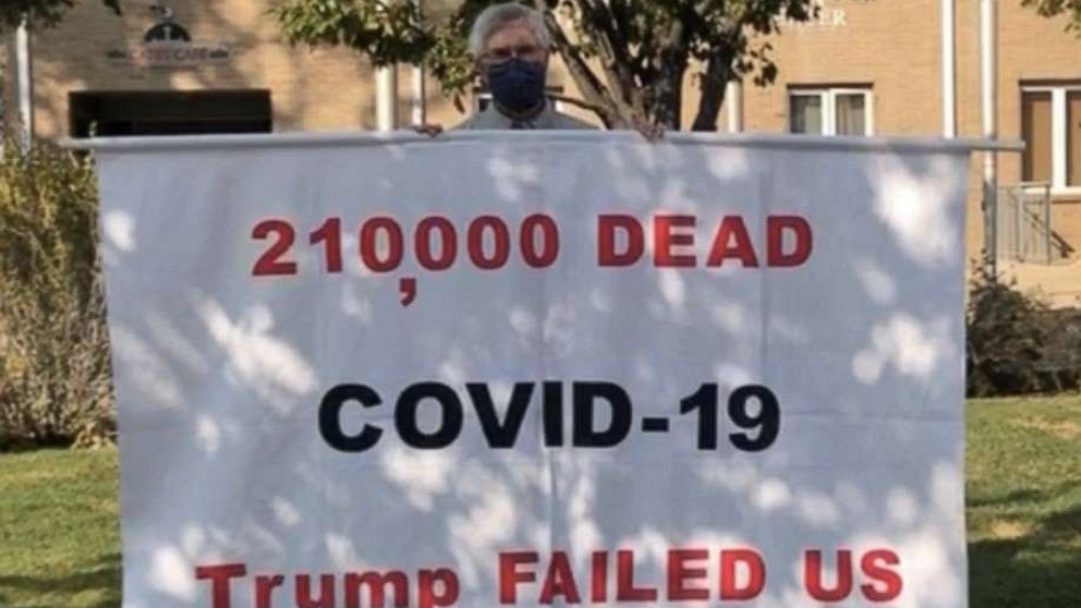 PHOTO: Tom Moran often drives thousands of miles holding a large banner that says, "220,000 DEAD. COVID-19. TRUMP FAILED US."