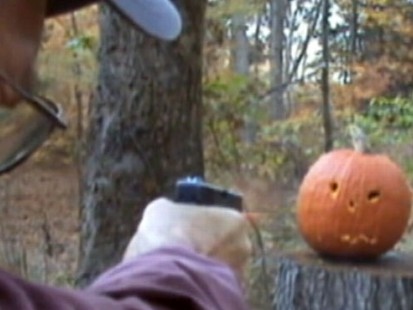 VIDEO: A man uses his gun to decorate a pumpkin with a face.