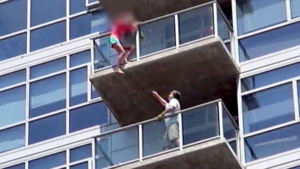 Stuntmen rushed into an apartment building to rescue a woman who was dangling from the balcony of the 14th floor. 