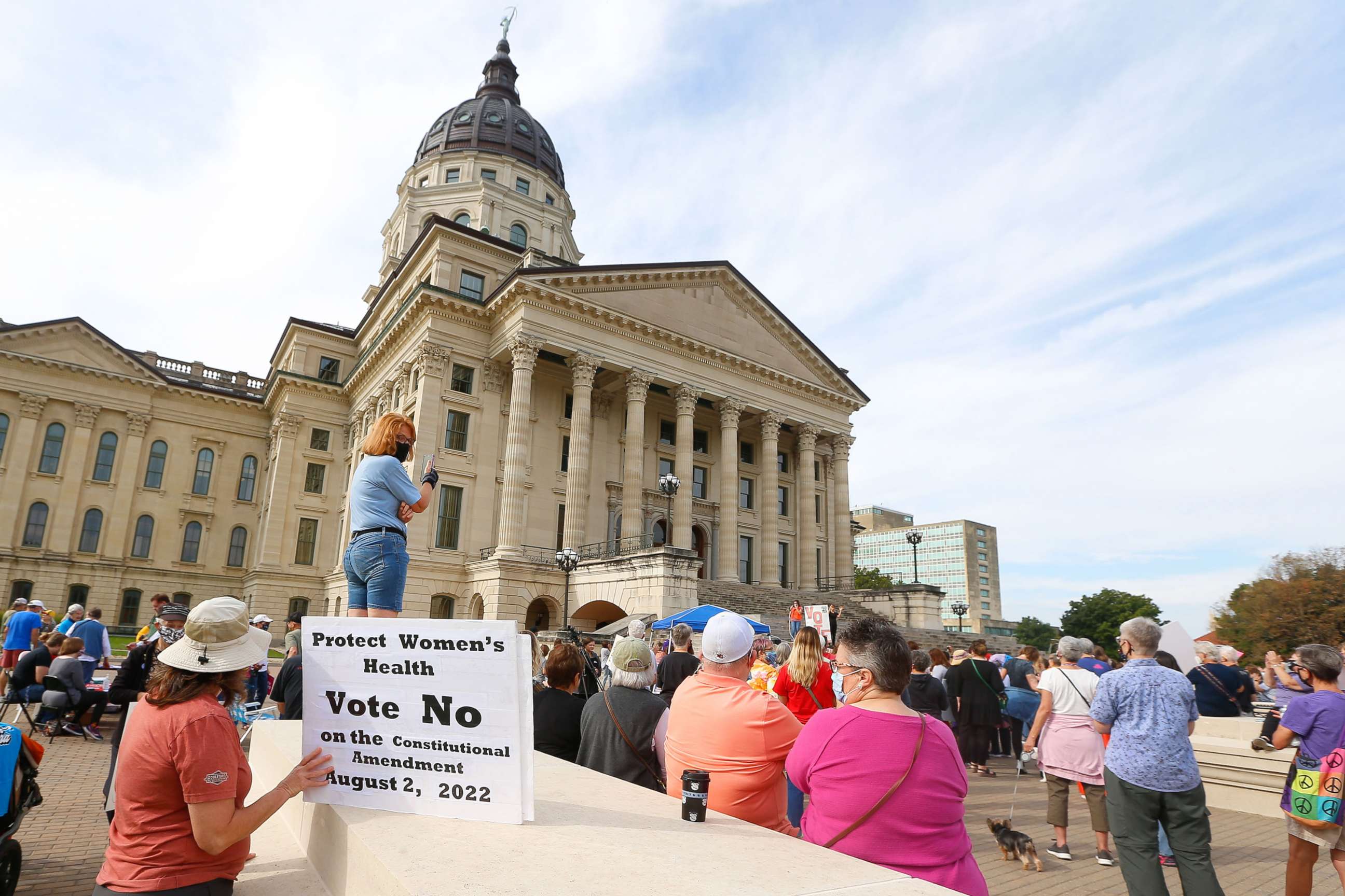 PHOTO: A woman holds a sign asking voters to vote no on an upcoming amendment to the Kansas Constitution regarding abortion during Saturday's National Women's March in Topeka, Oct. 2, 2021.