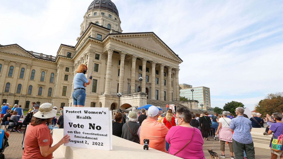 PHOTO: A woman holds a sign asking voters to vote no on an upcoming amendment to the Kansas Constitution regarding abortion during Saturday's National Women's March in Topeka, Oct. 2, 2021.