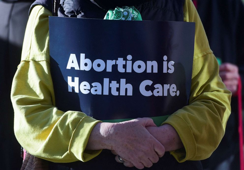 PHOTO: Kathy Thomas holds a sign reading, "Abortion is Health Care" during the Women's March protest outside of the Federal Courthouse in Amarillo, Texas, March 15, 2023.